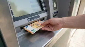 Mano che preleva banconote da 50 euro da uno sportello bancomat, simbolo dei limiti di prelievo dal conto